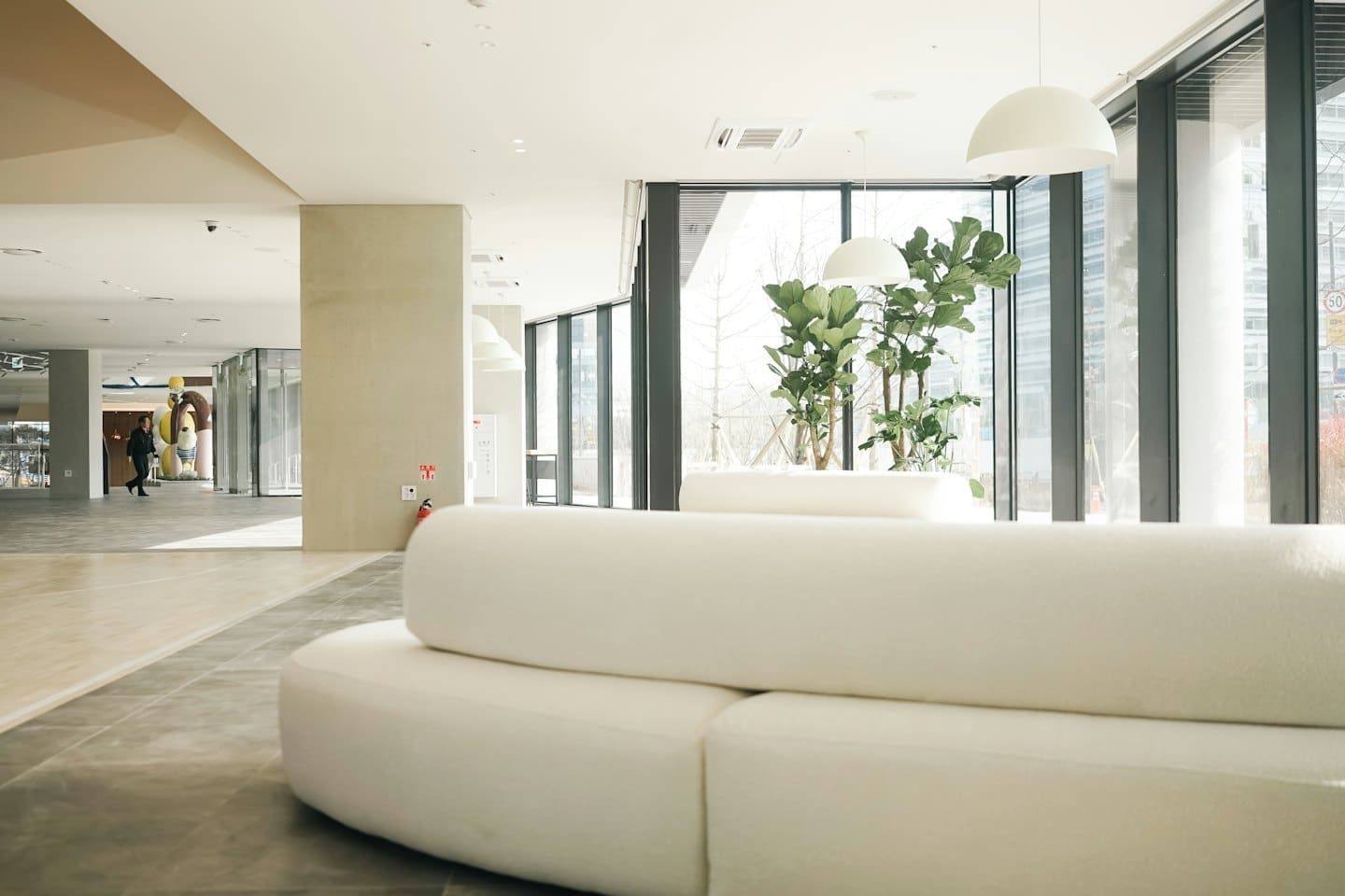 Lobby moderna con divani curvi e grandi finestre.